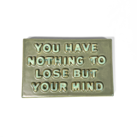 A rectangular ceramic sign with raised lettering that reads 'YOU HAVE NOTHING TO LOSE BUT YOUR MIND' in a light mint green color against a matte sage green background, shown on a plain white background.