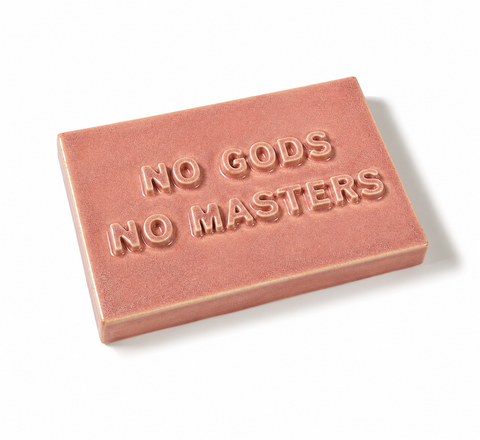 A rectangular pink ceramic sign with the text 'NO GODS NO MASTERS' in all caps, shown on a plain white background.